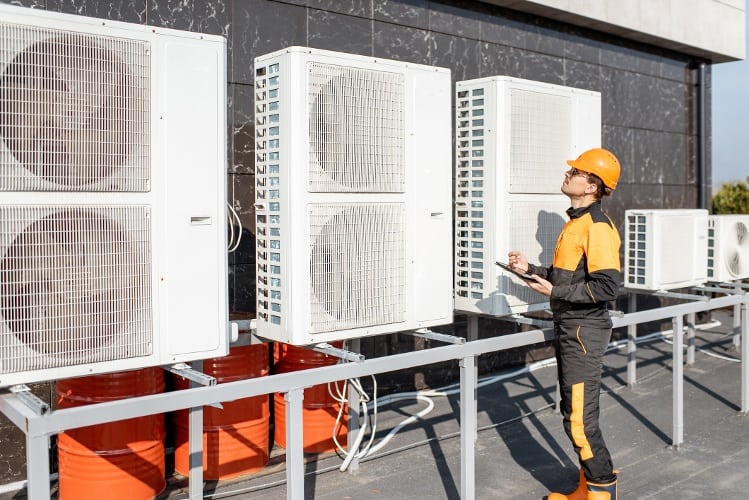 service worker check up on HVAC / AC units outside on roof