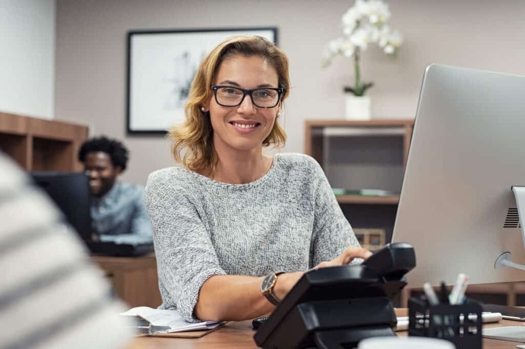 Human at desk with cell phone