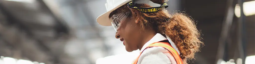 photo of smiling woman in hard hat and safety vest